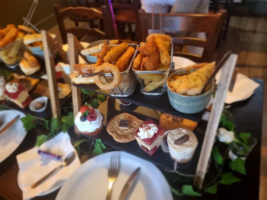 An afternoon tea tier stacked with cakes, pastries and savouries.