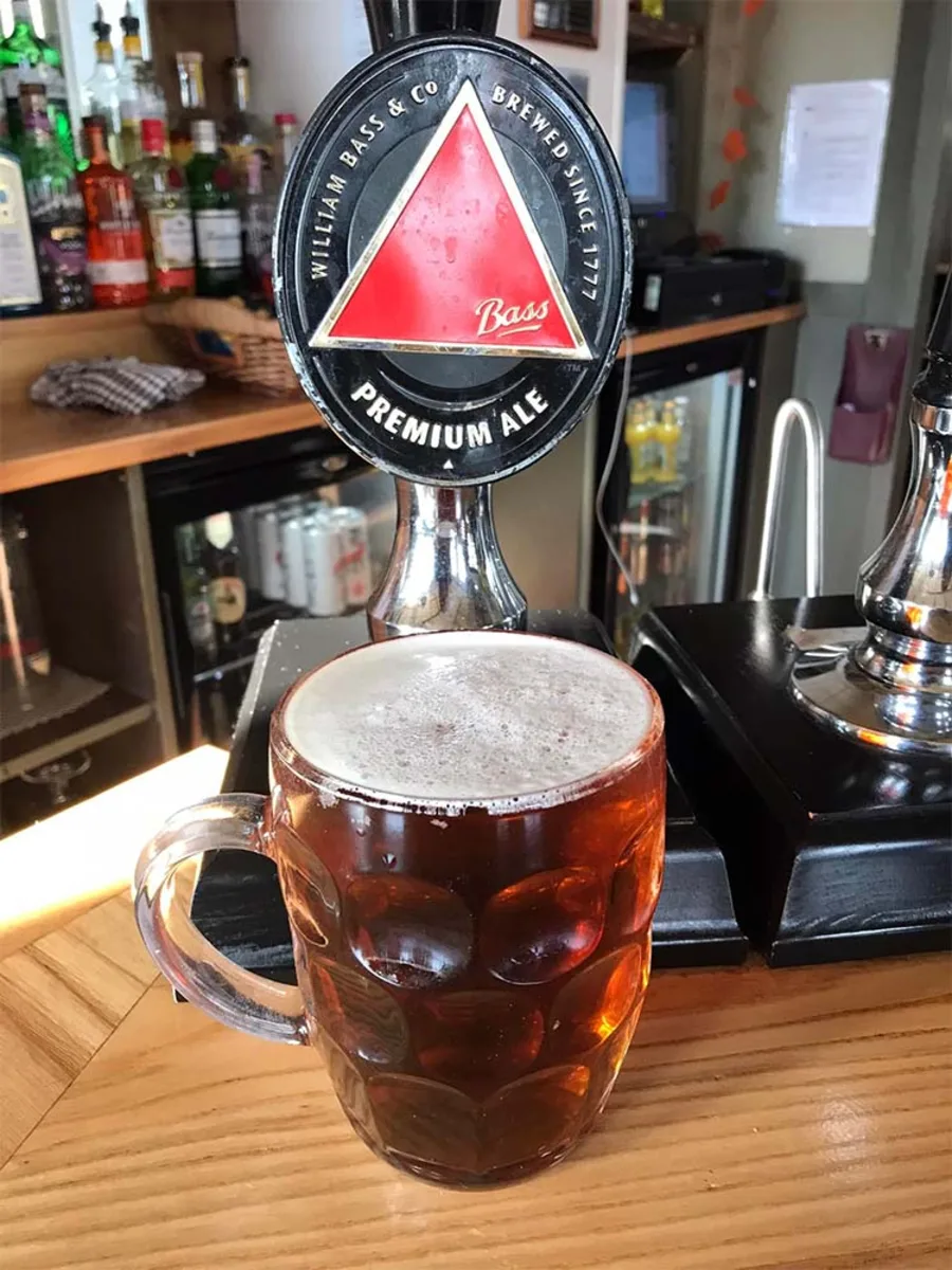 A pint pulled at the bar, standing in front of the pumps.